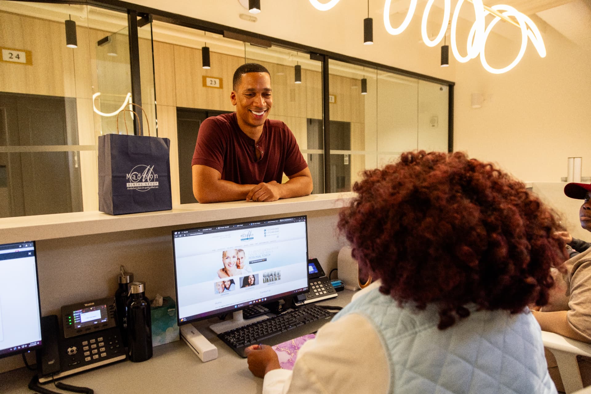 A patient checking out at the Madison Dental Group front desk