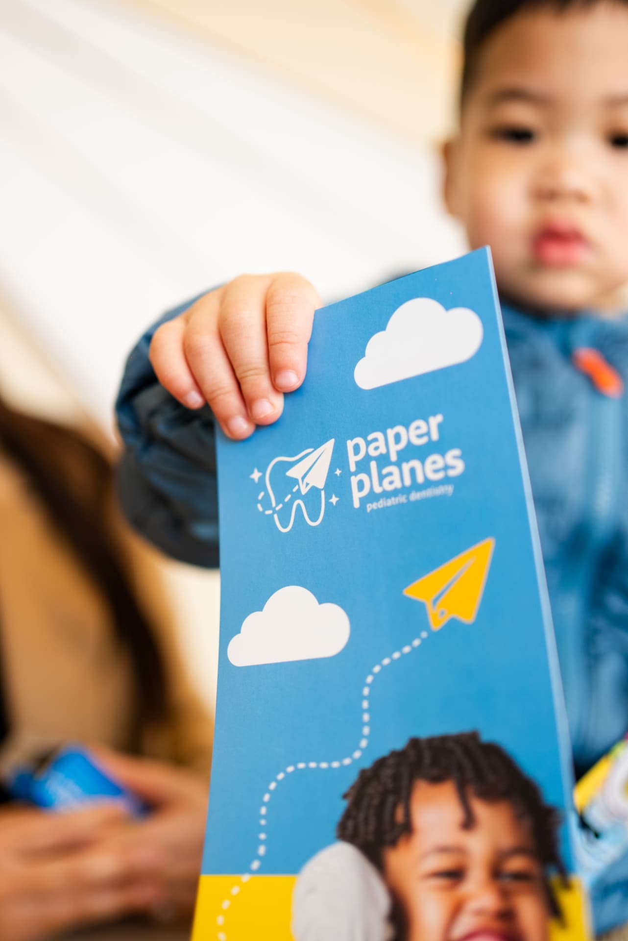 A young patient holding a branded Paper Planes brochure